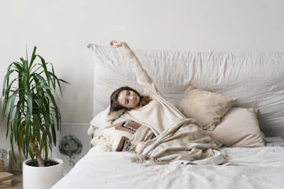 a woman laying on a bed with a blanket