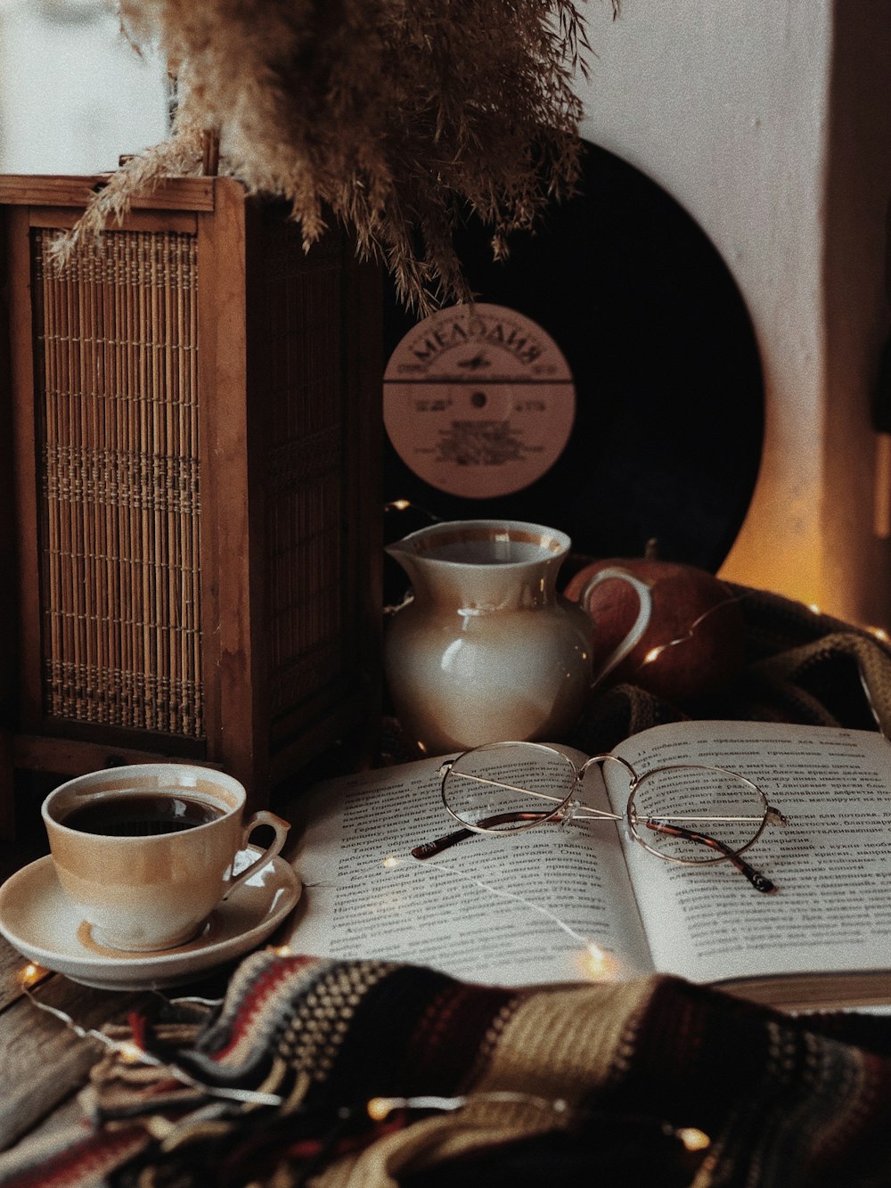 an open book sitting on top of a table next to a cup of coffee