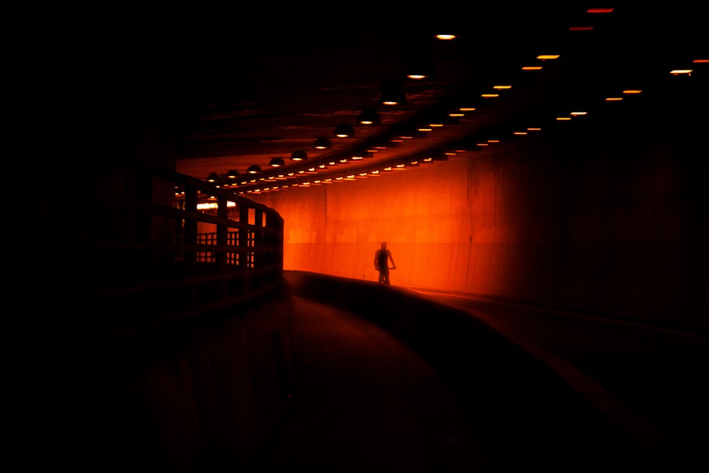 a person standing alone in a dark tunnel