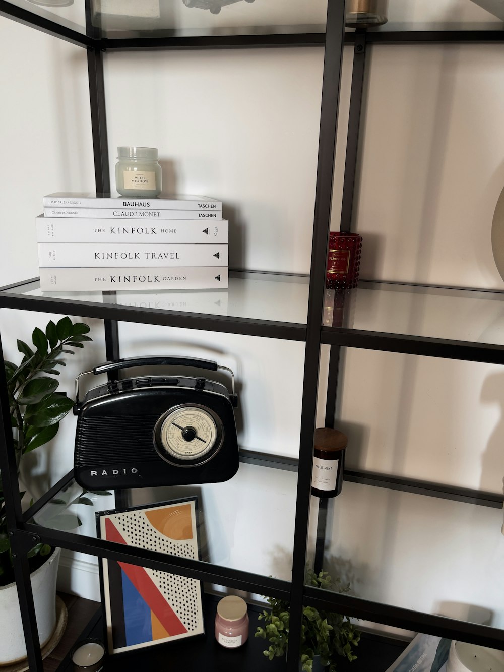 a bookshelf with a clock and a radio on top of it