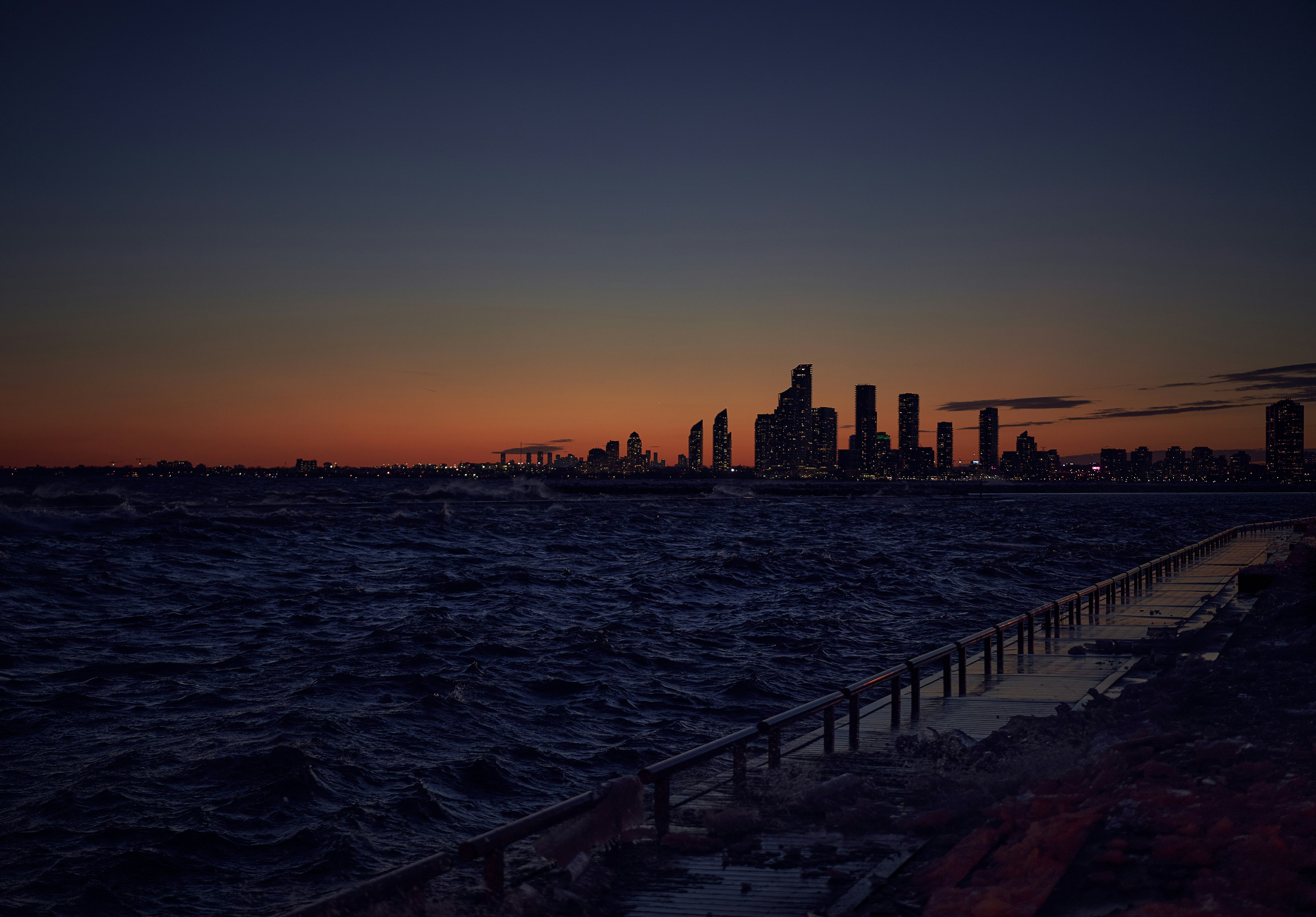 a view of a city from the ocean at sunset