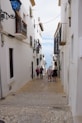 a group of people walking down a narrow street