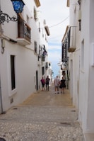 a group of people walking down a narrow street