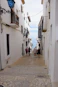 a group of people walking down a narrow street