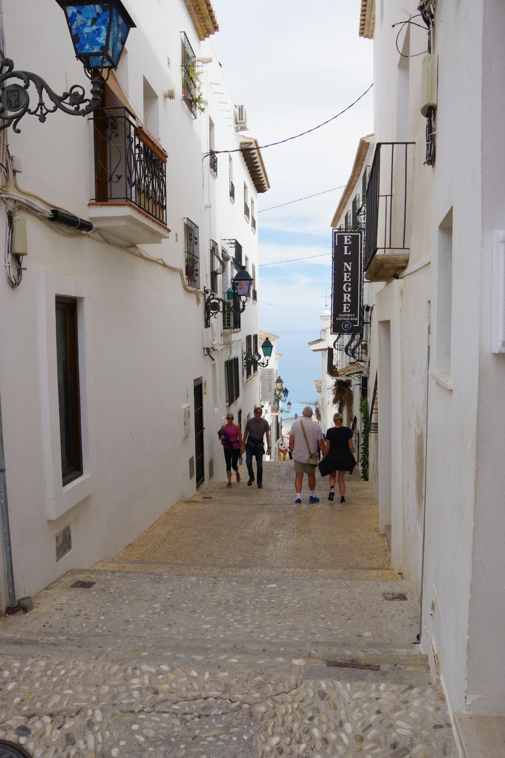 Un grupo de personas caminando por una calle estrecha