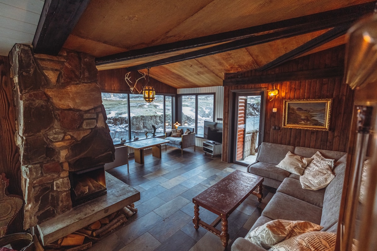 A cosy living room with a stone fireplace and warm rustic interior