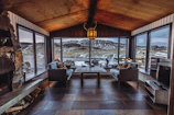 Warm fireplace in the living area with plush seating and mountain views through large windows.