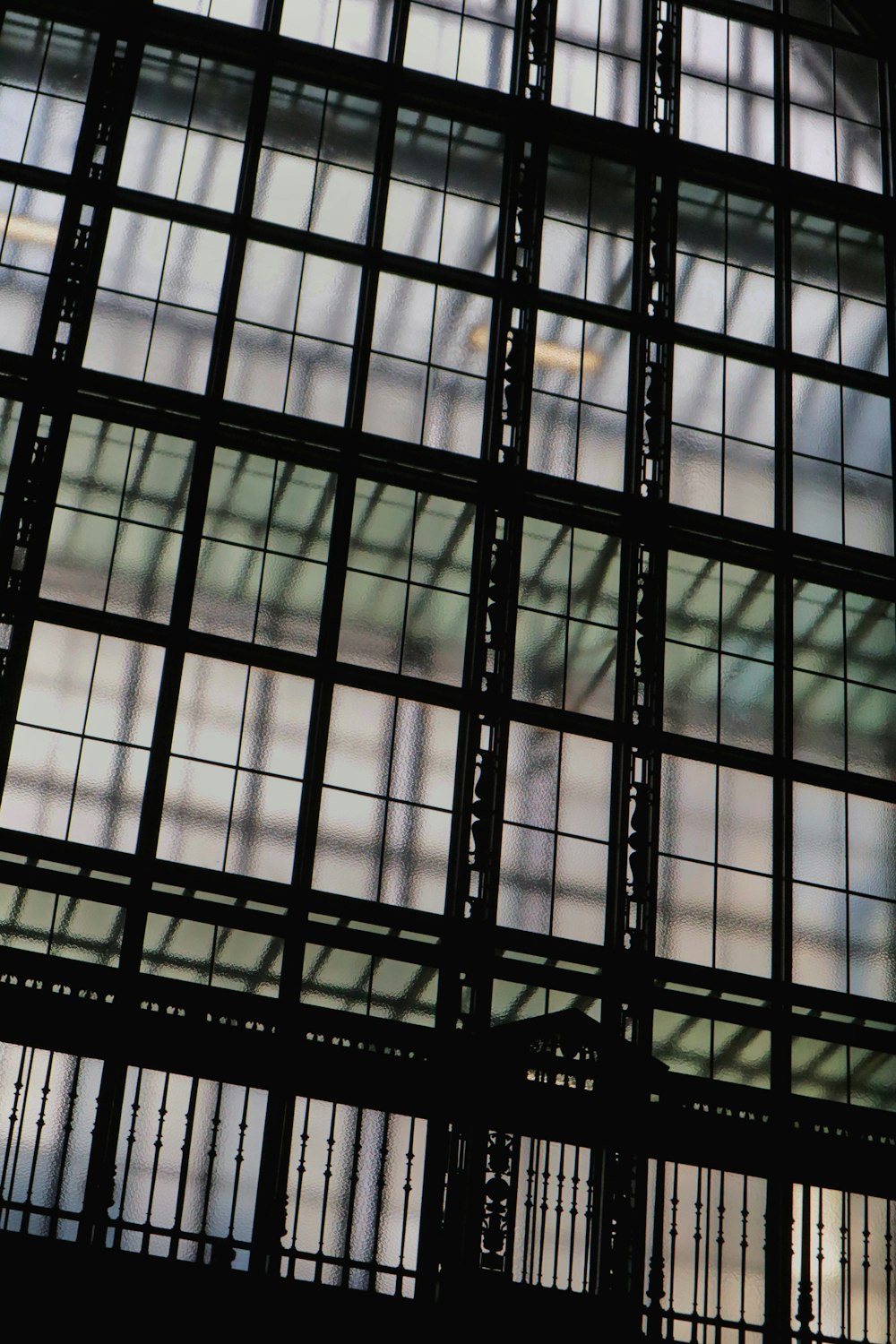 a clock is seen through the windows of a building