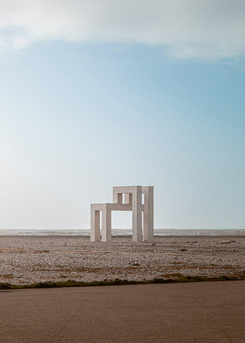 a large white chair sitting in the middle of a desert