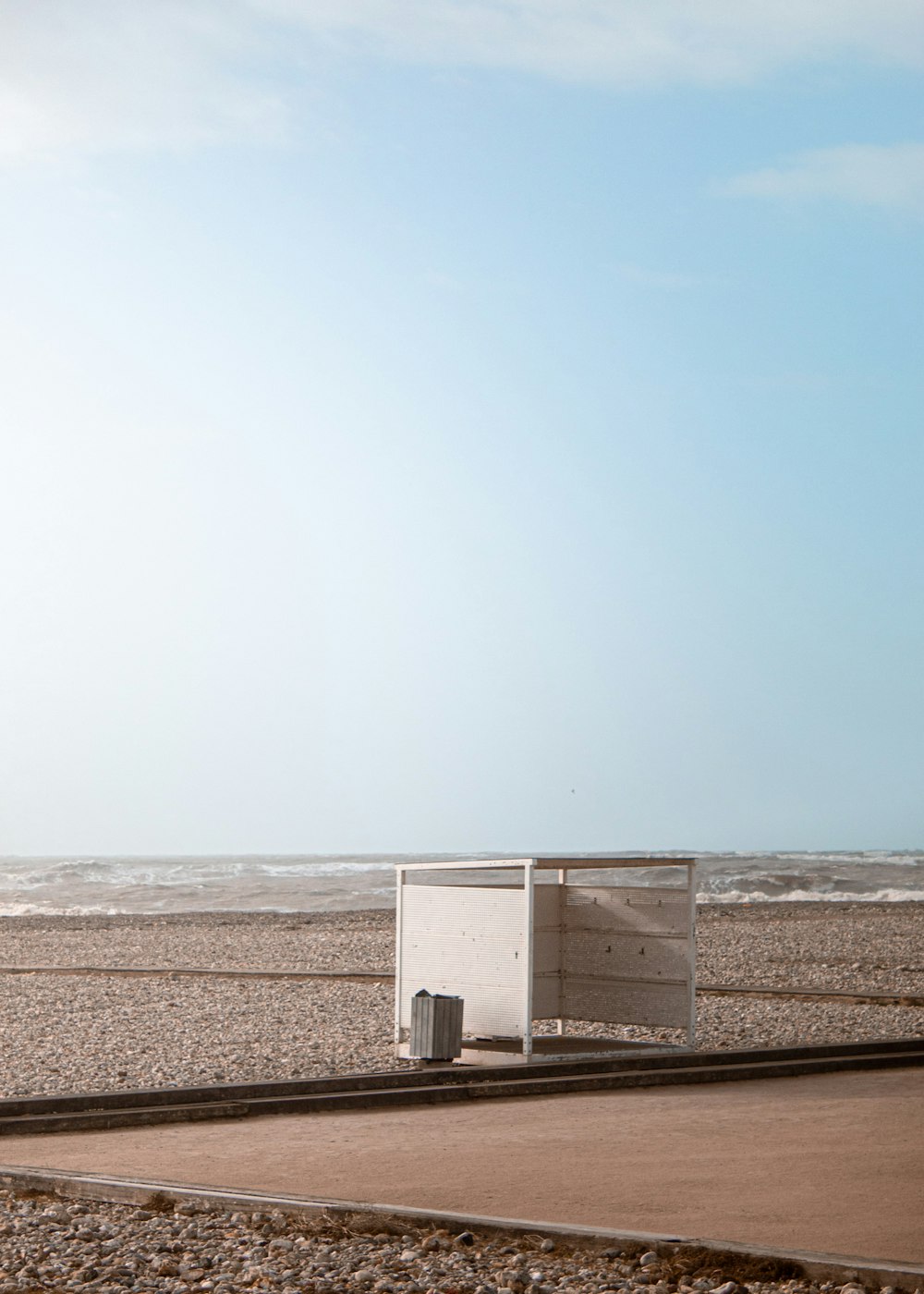 Una caja blanca sentada en la parte superior de una playa de arena