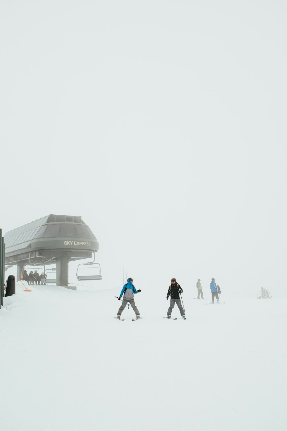 a group of people riding skis down a snow covered slope