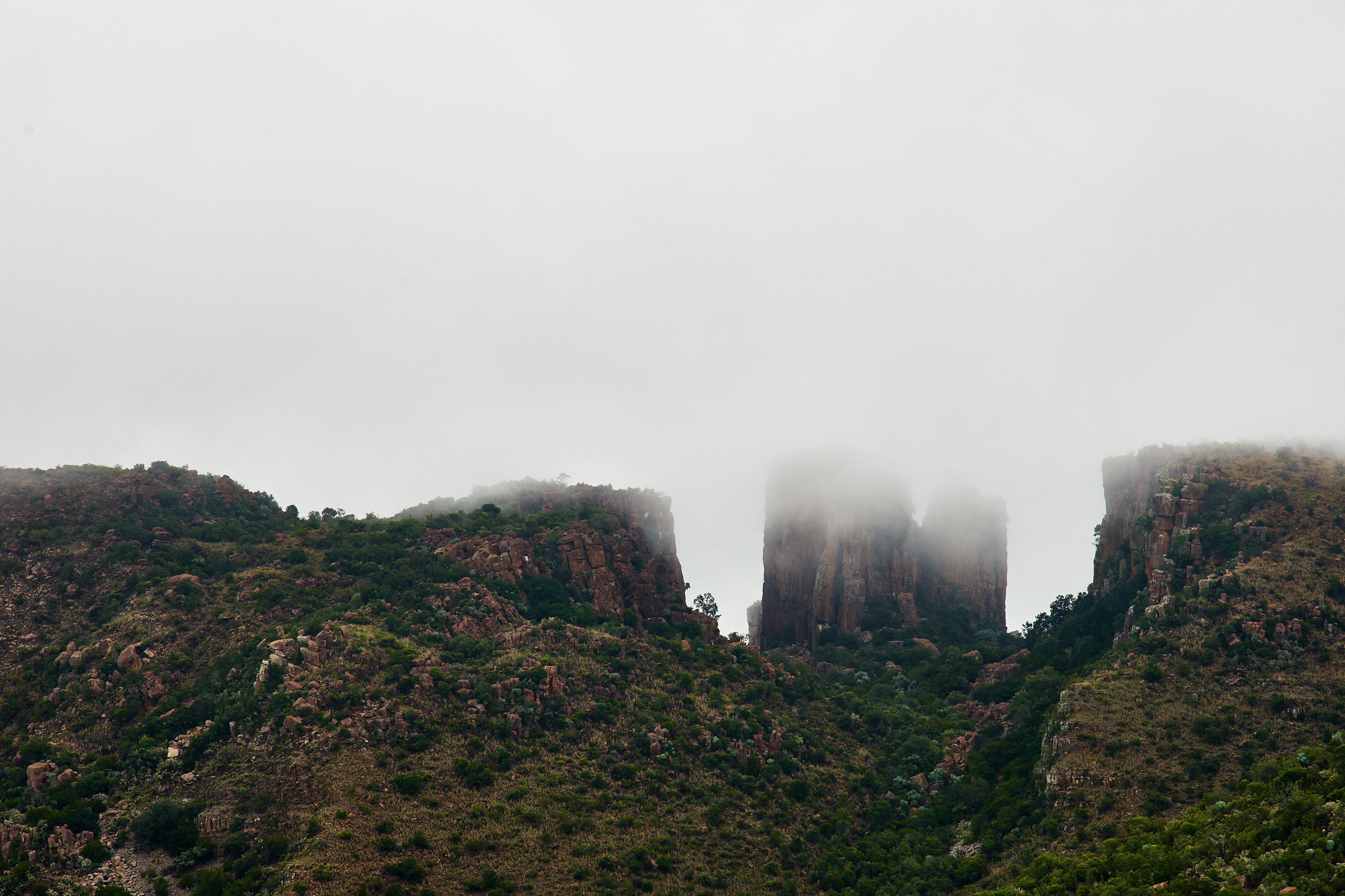 A very tall mountain covered in fog and clouds photo – Free Nature ...