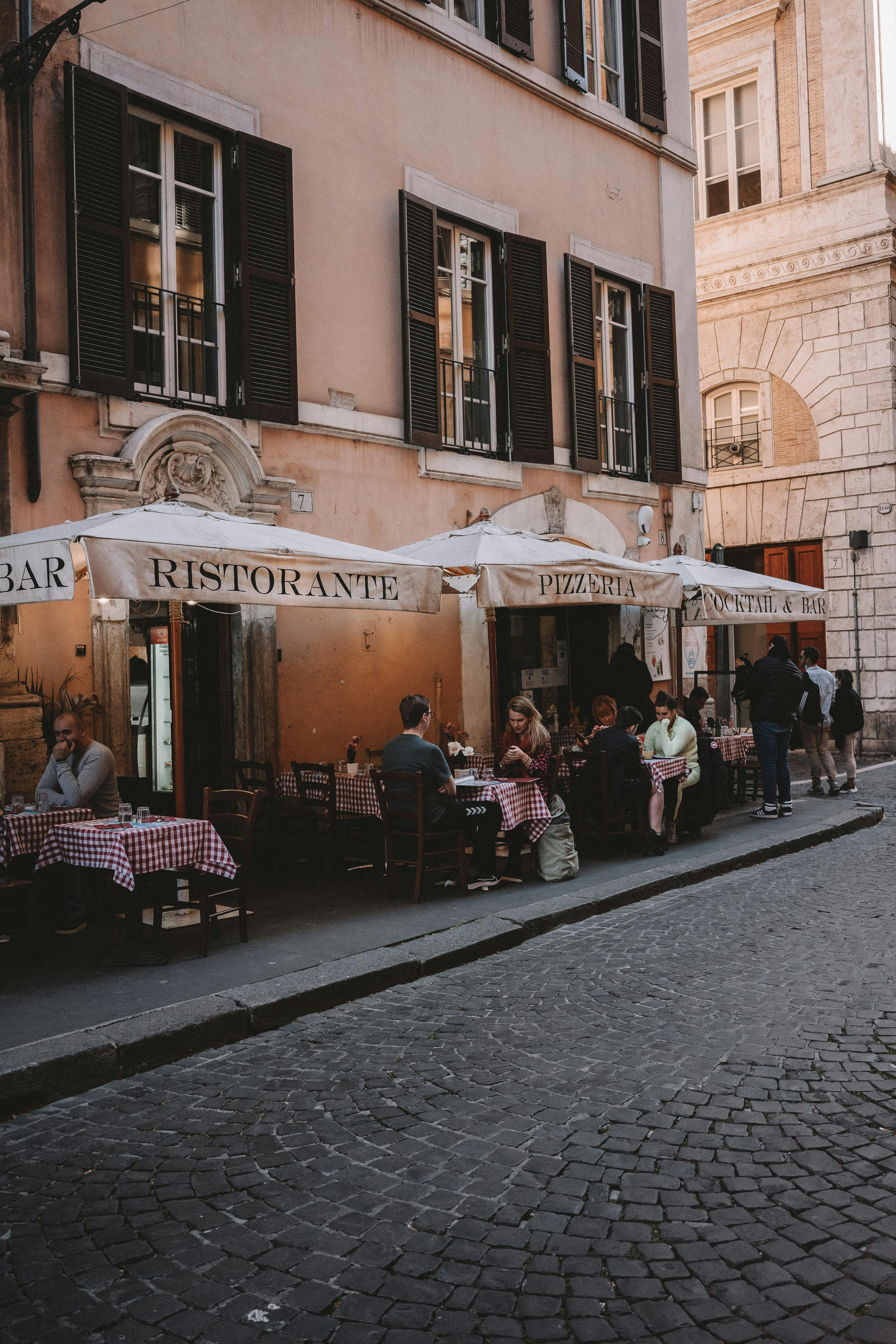 a group of people sitting outside of a restaurant