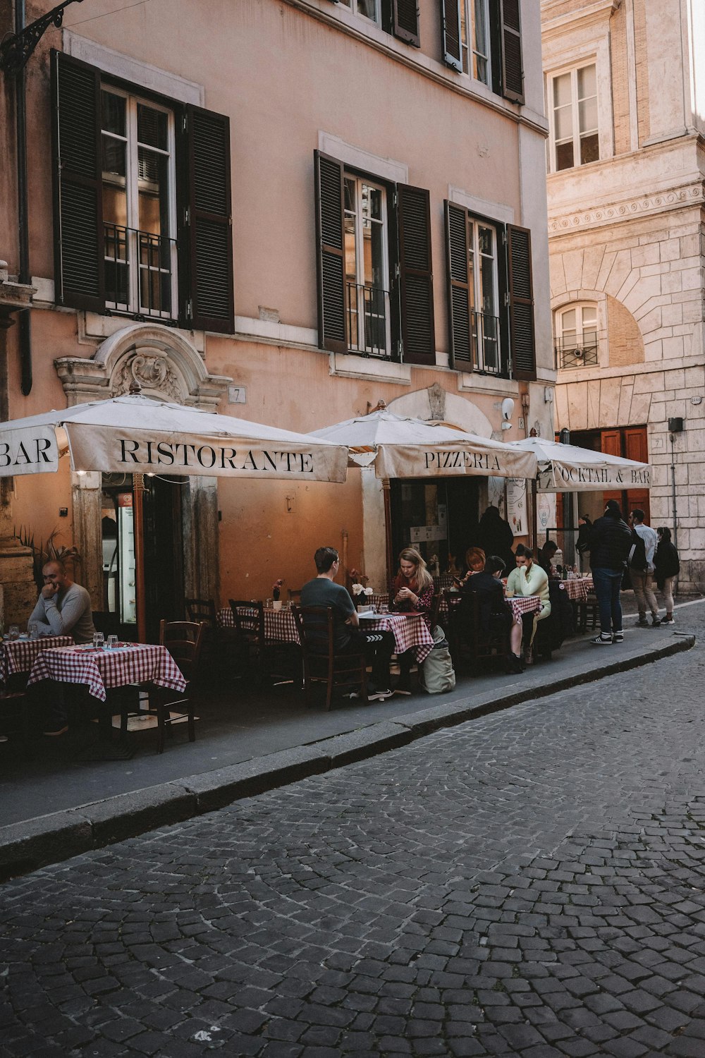 a group of people sitting outside of a restaurant