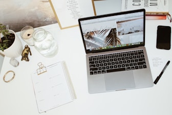 a laptop computer sitting on top of a white desk