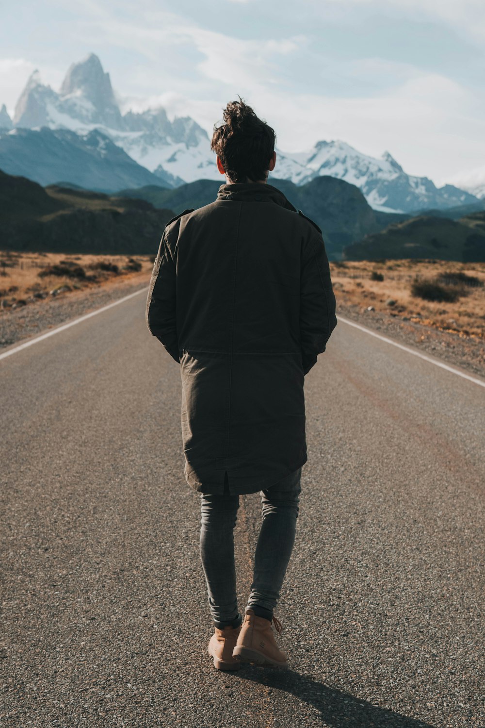 a man walking down the middle of a road