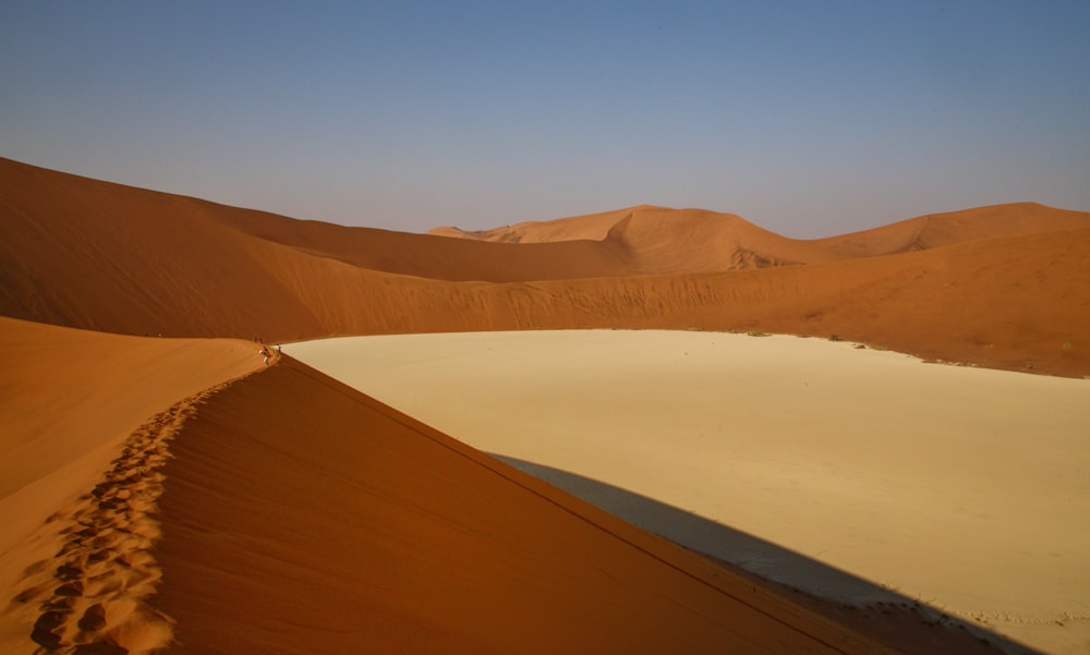 a person walking across a sandy area in the desert