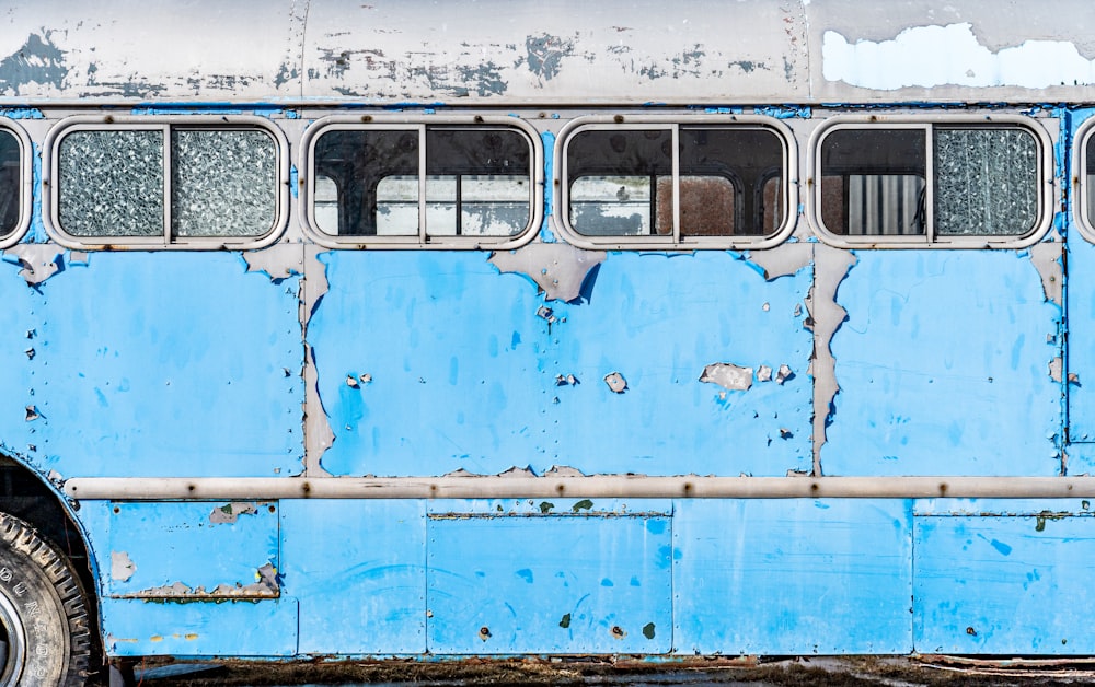 an old blue bus with peeling paint on it