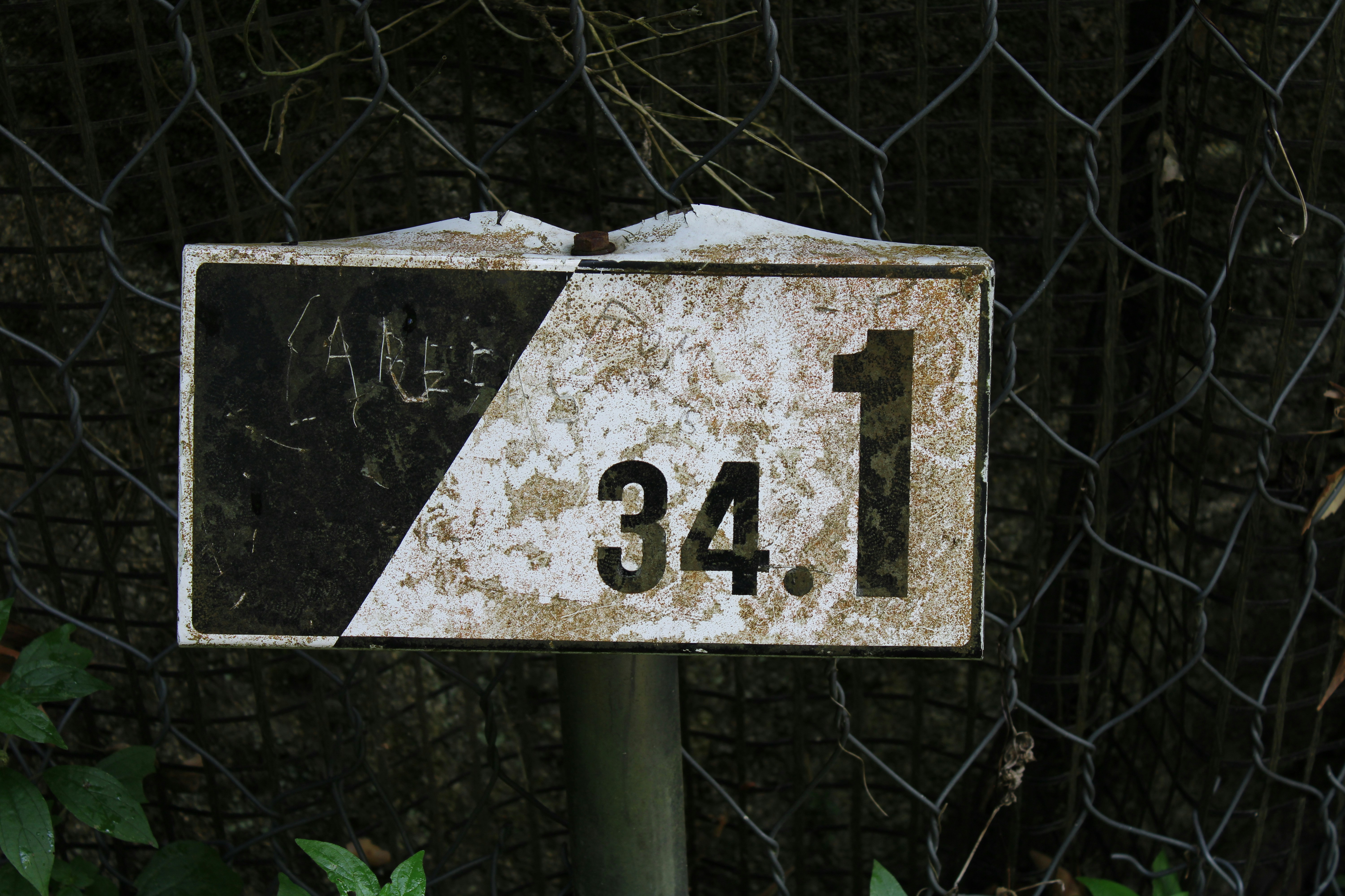 a sign that is on a pole in front of a fence