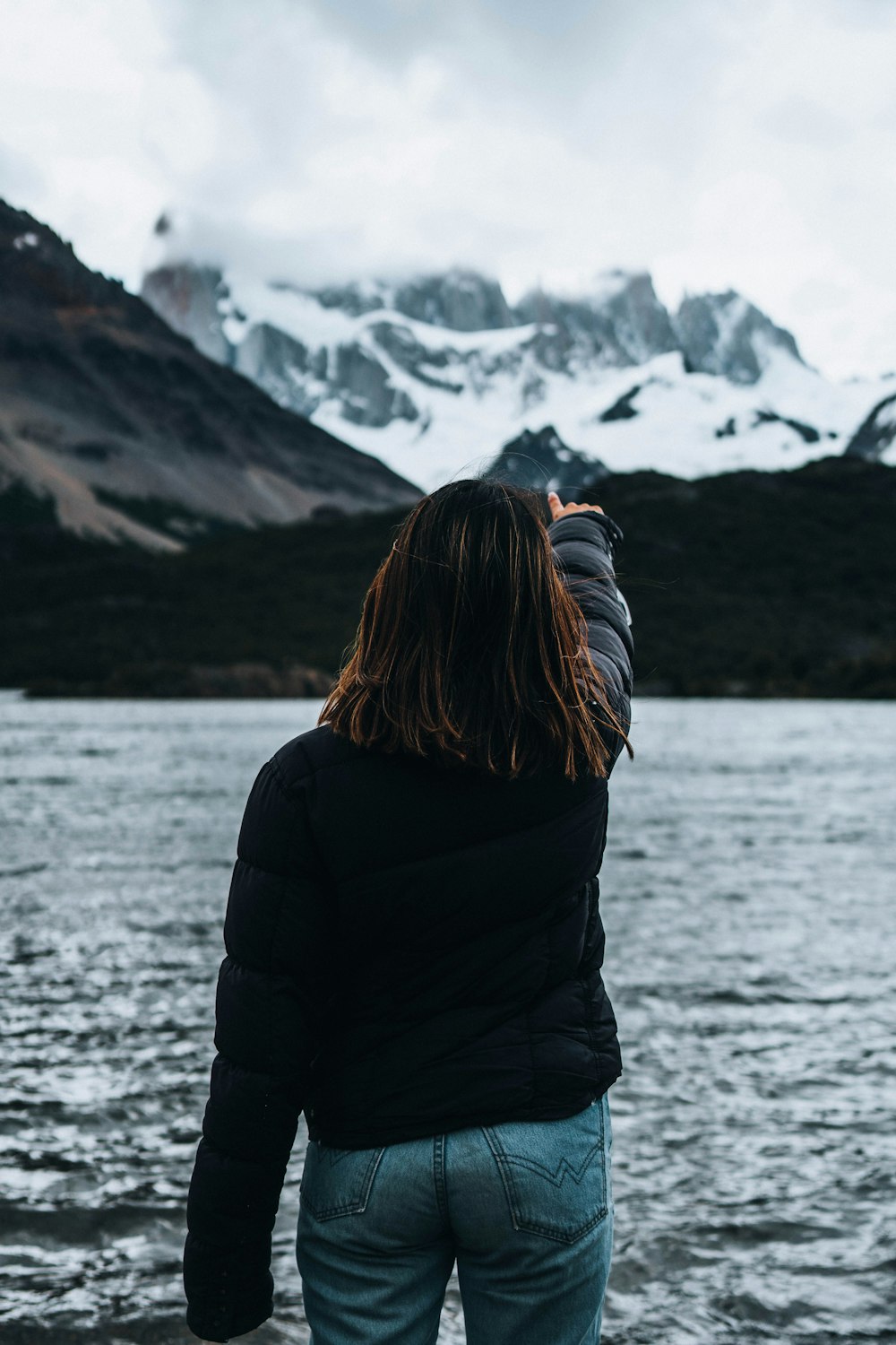 a woman standing in front of a body of water