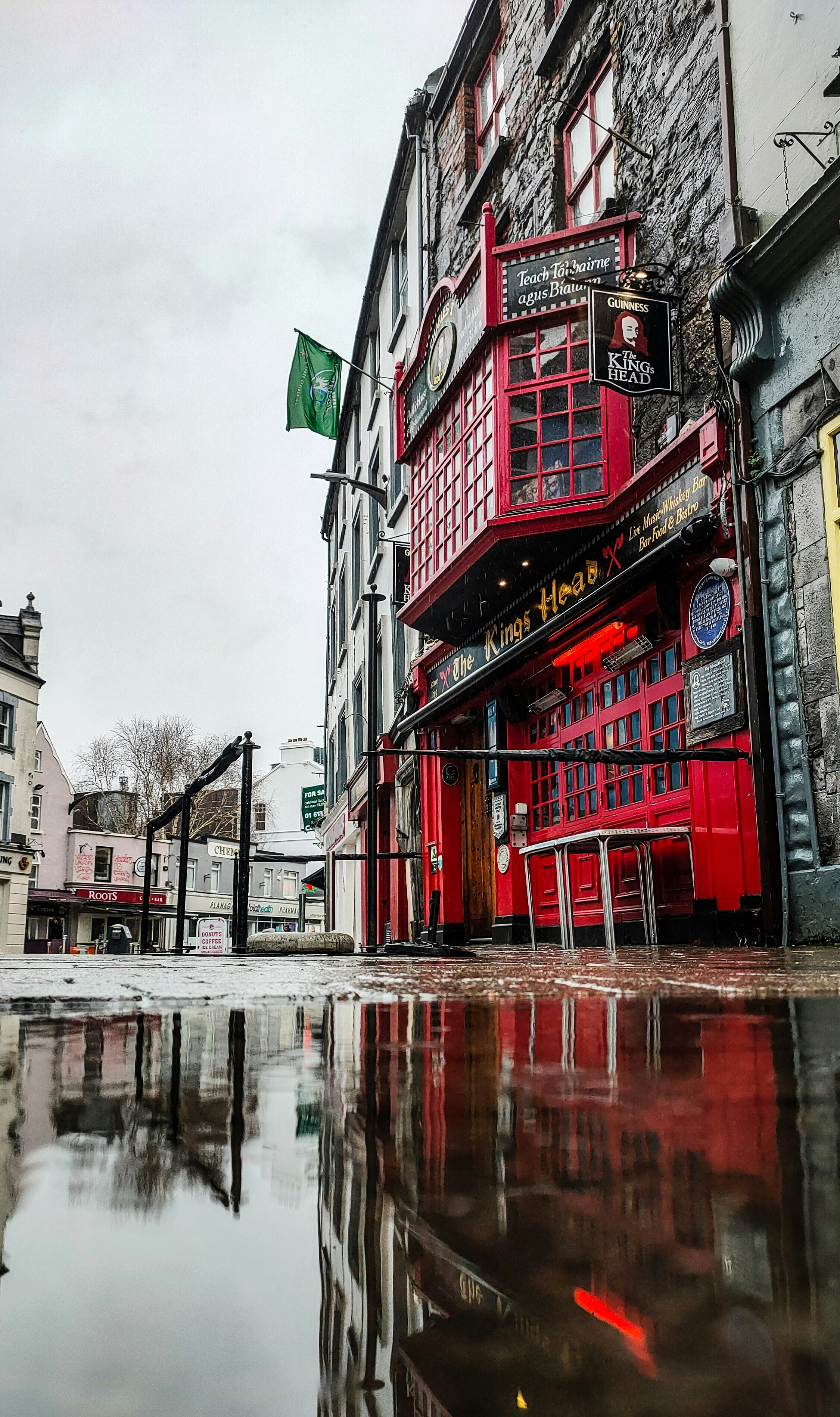 a red building sitting on the side of a wet street