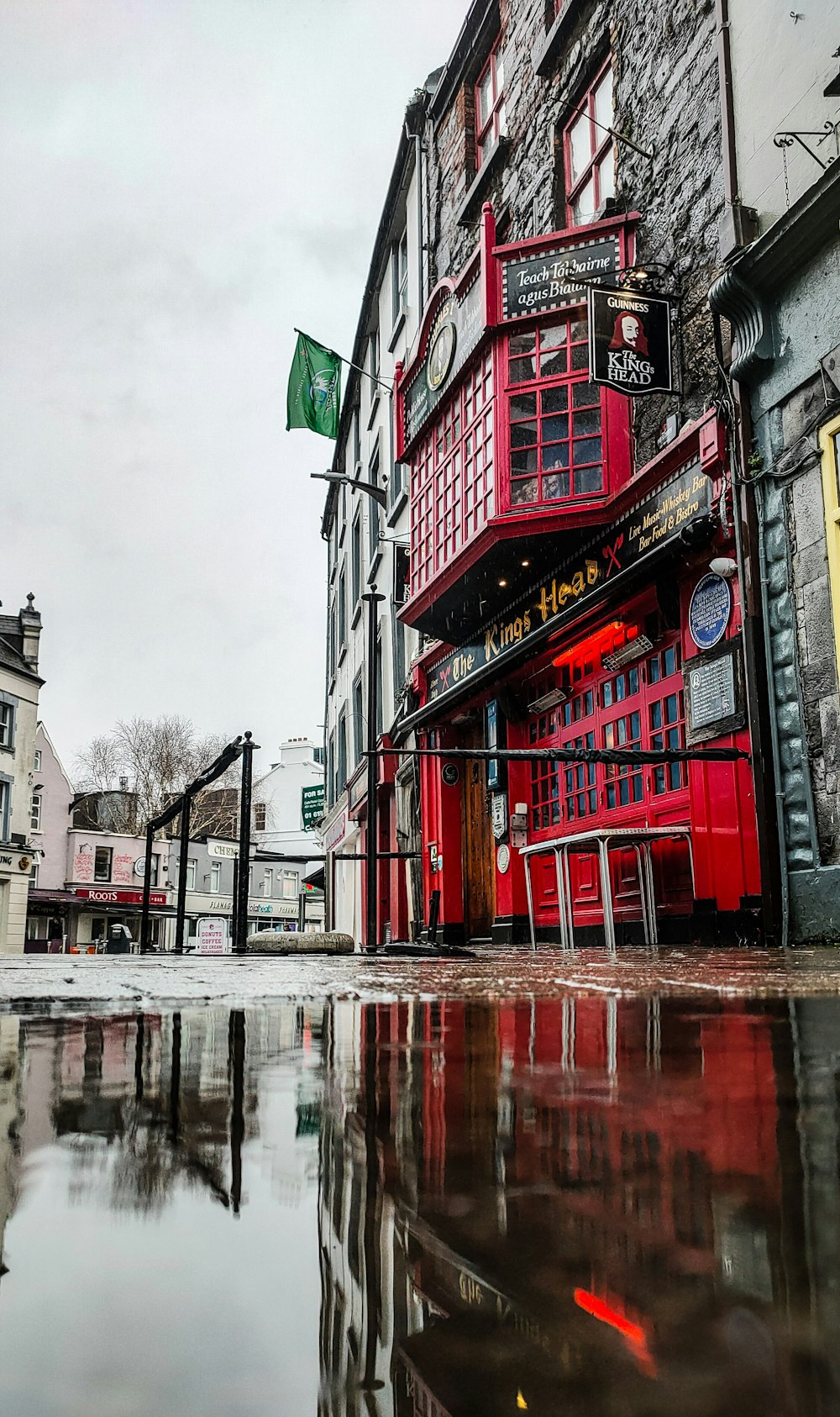 a red building sitting on the side of a wet street