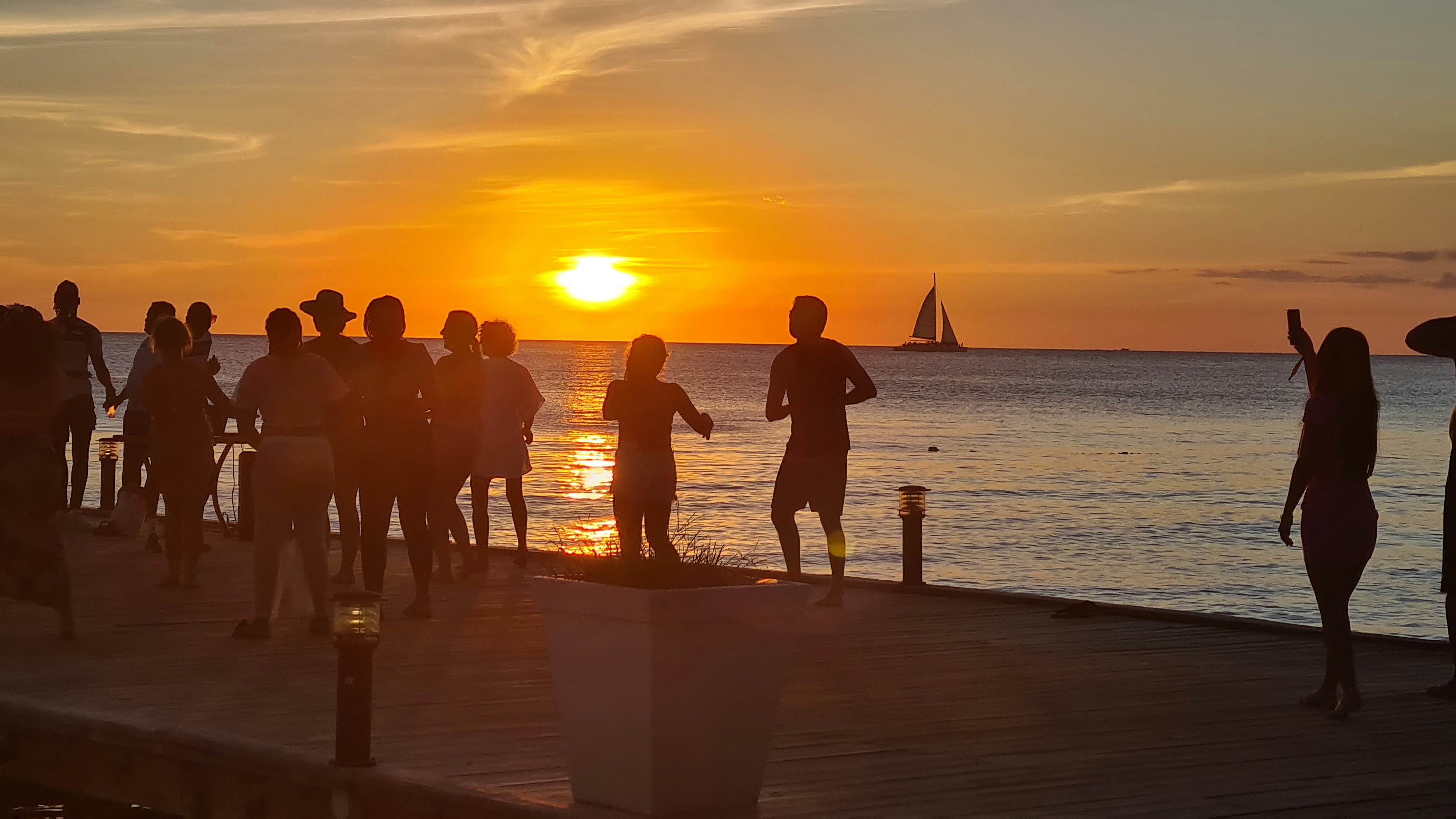 a group of people standing on top of a pier