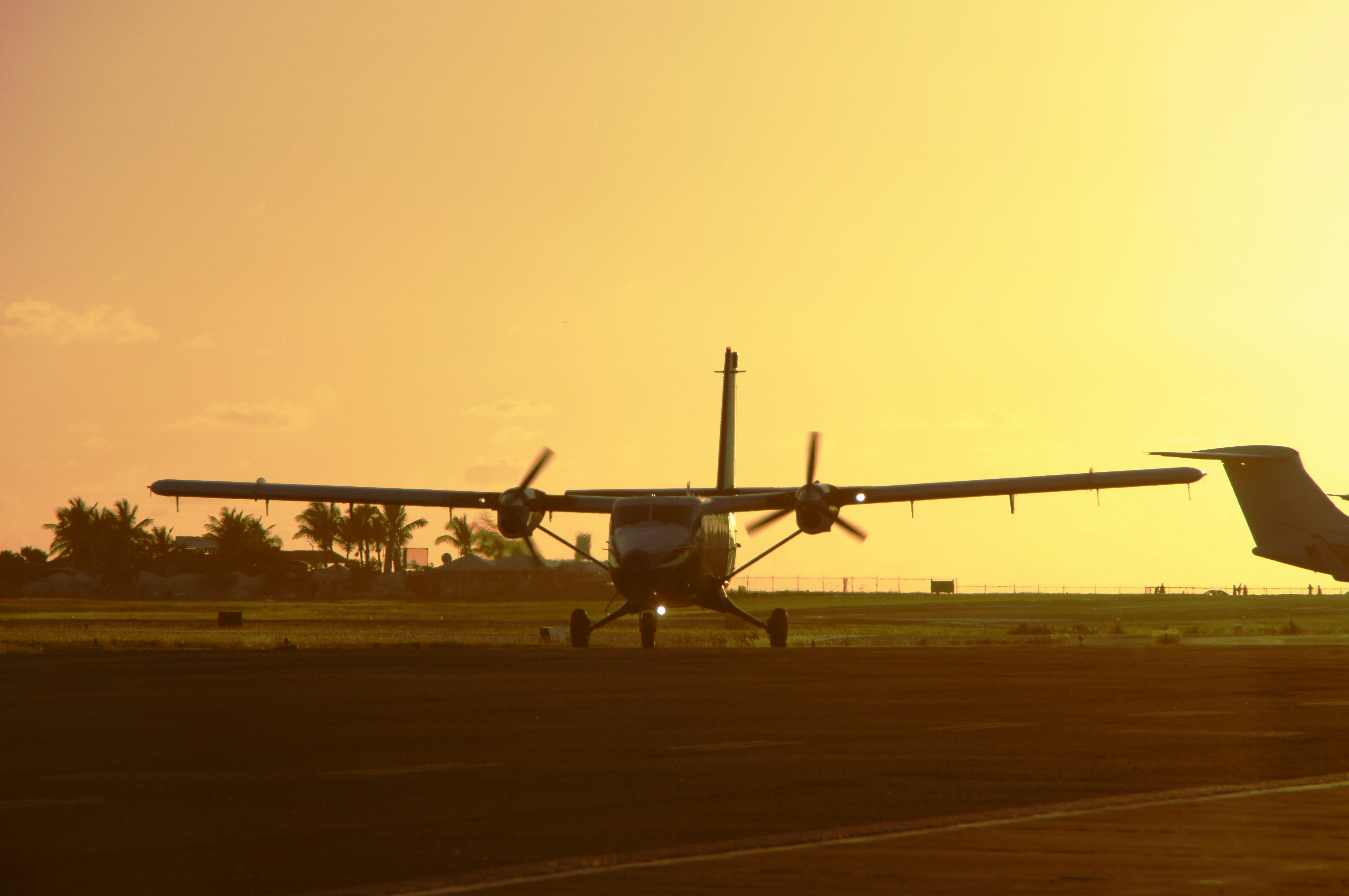 a plane that is sitting on a runway, sunset landing