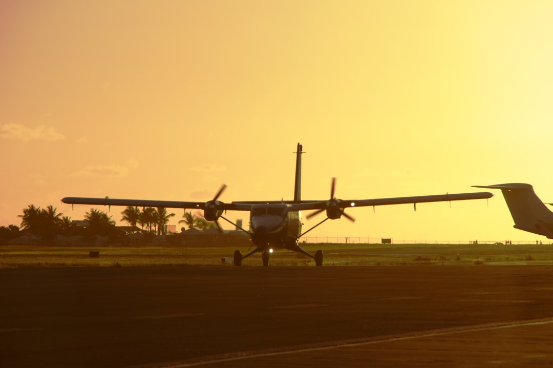 a plane that is sitting on a runway, sunset landing