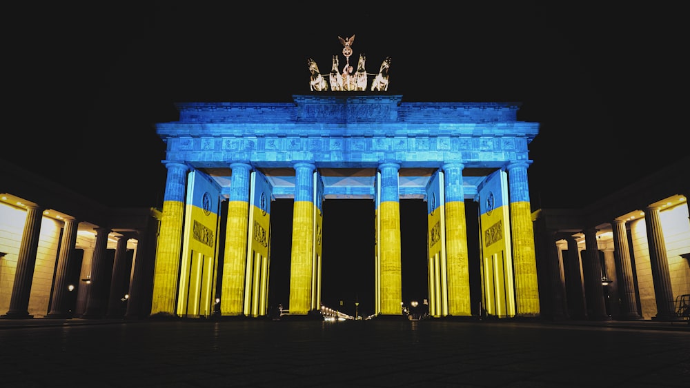 a large blue and yellow arch lit up at night