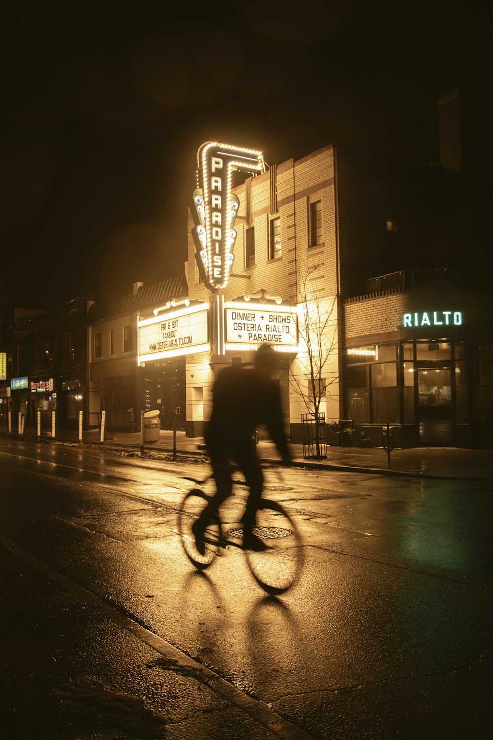 a man riding a bike down a street at night