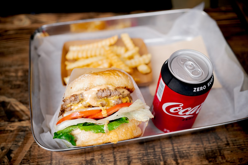 a tray with a sandwich, french fries and a soda