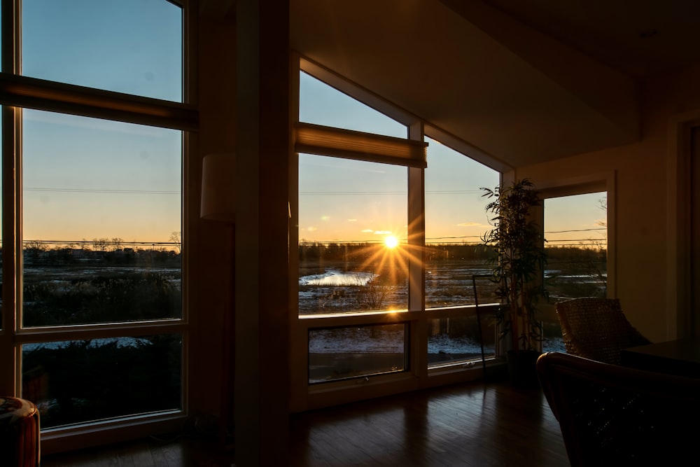 the sun is setting through the windows of a house