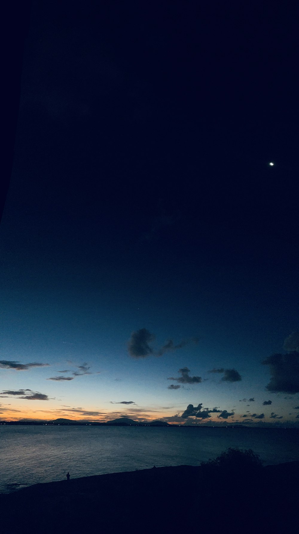 a person sitting on a bench watching the sunset