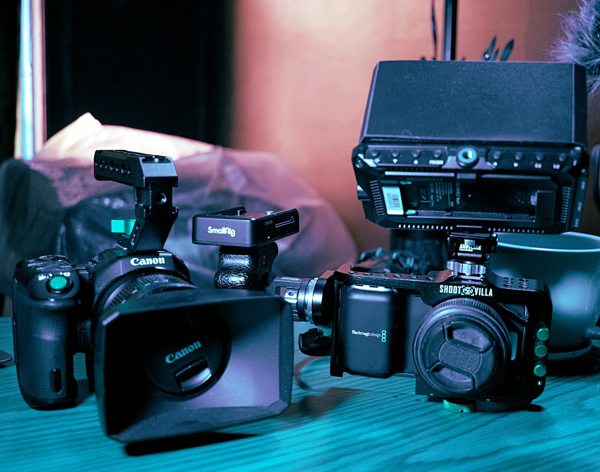 a couple of cameras sitting on top of a wooden table