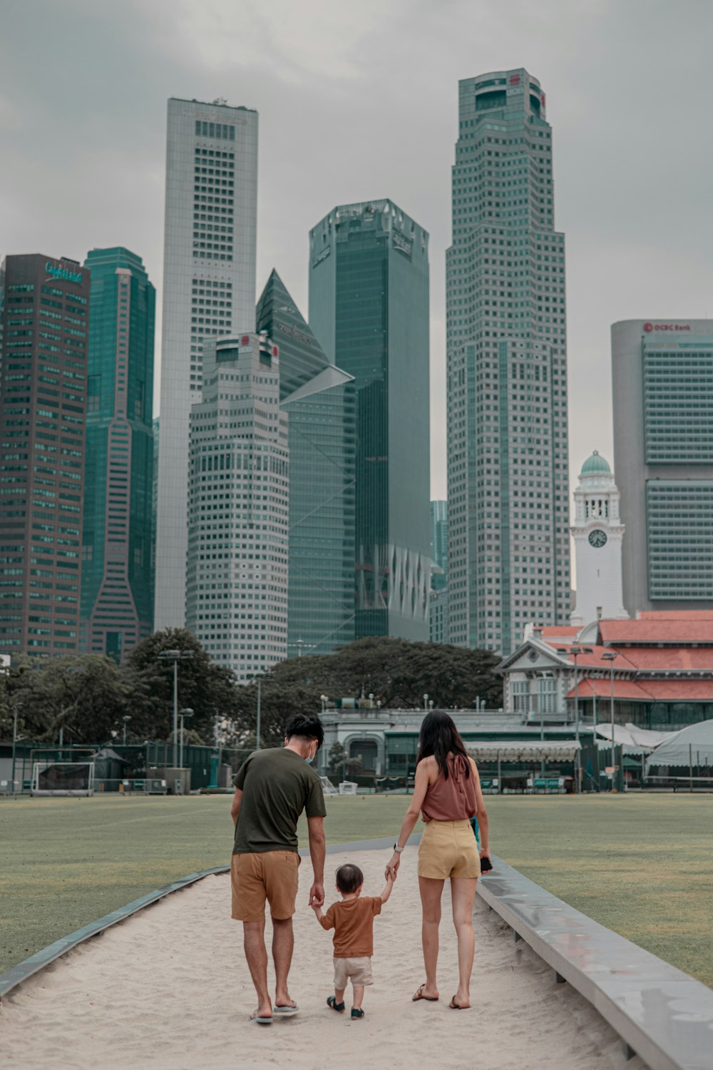 a man and a woman holding hands while walking with a small child