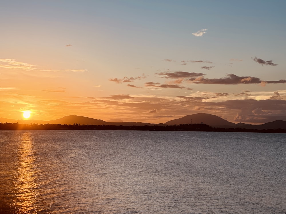 the sun is setting over a body of water