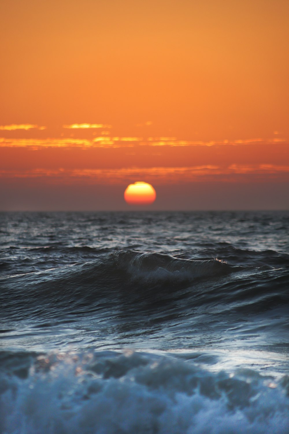 the sun is setting over the ocean waves