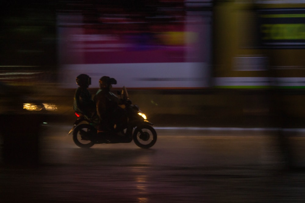 a couple of people riding on the back of a motorcycle