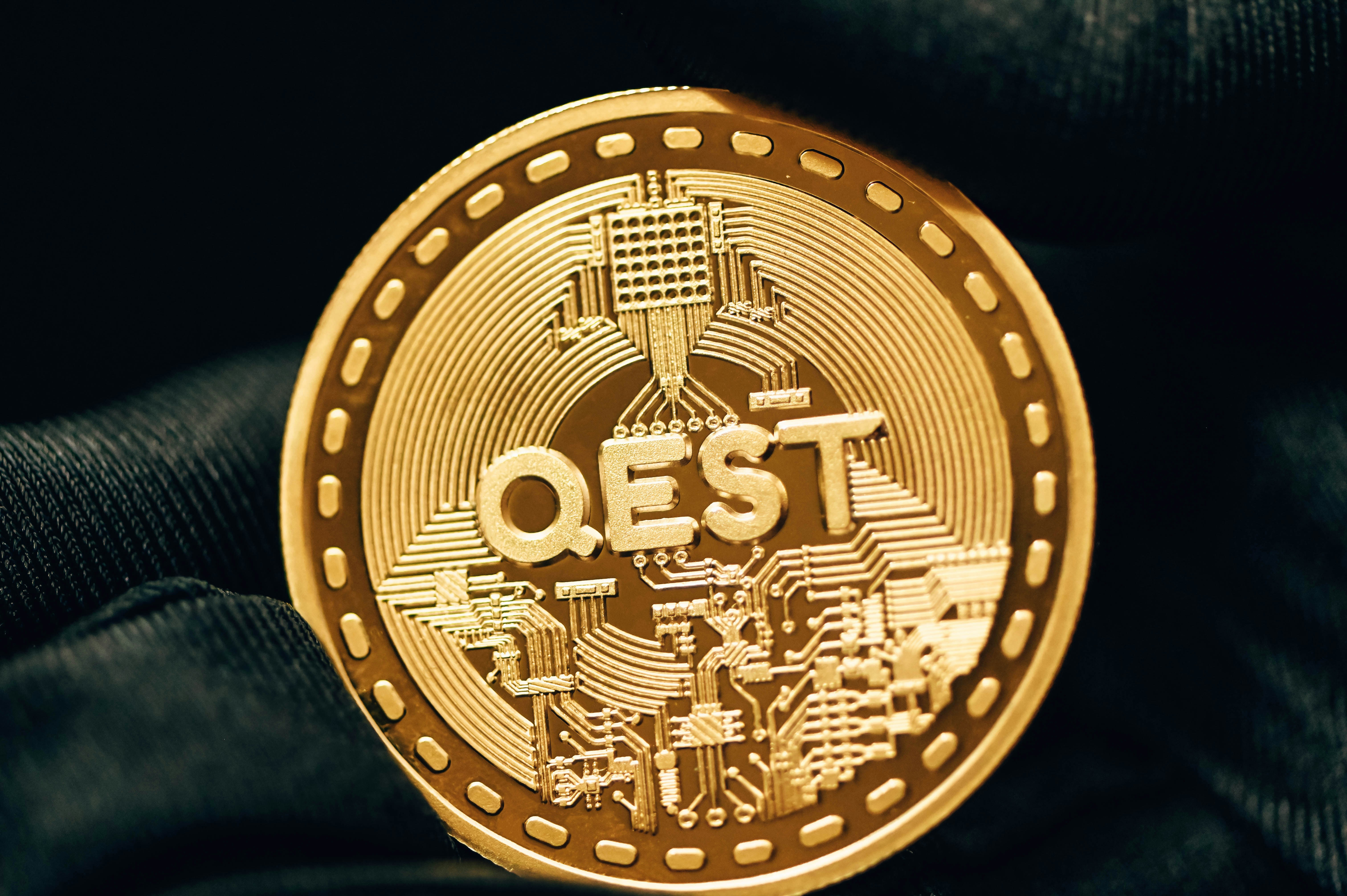 a gold coin with the word qest printed on it