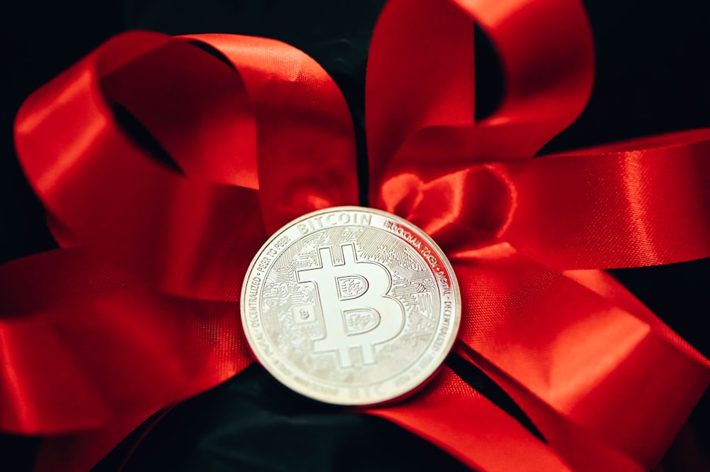 Un bitcoin atado a una cinta roja