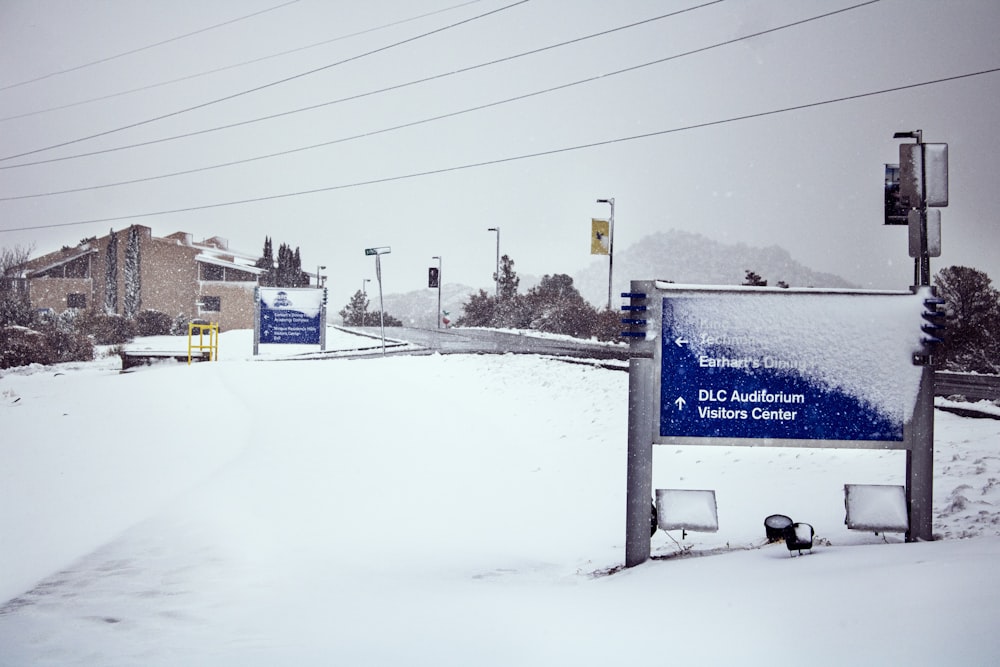 a street sign covered in snow next to a building