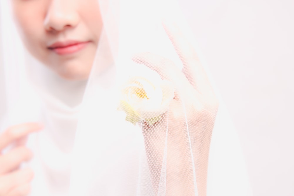 a woman wearing a veil and holding a flower
