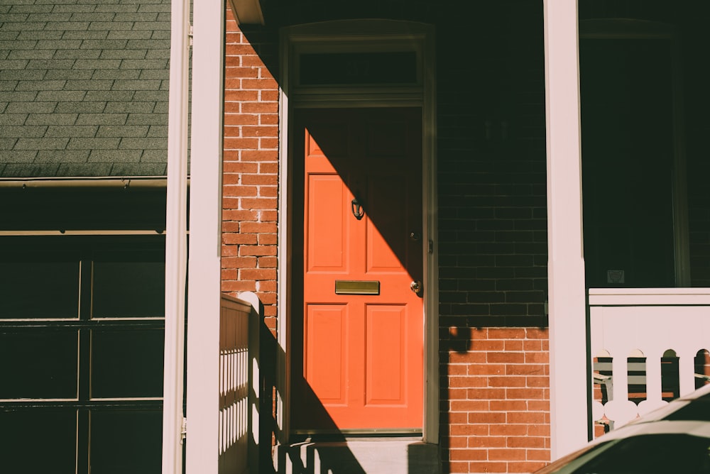 a car is parked in front of a red door