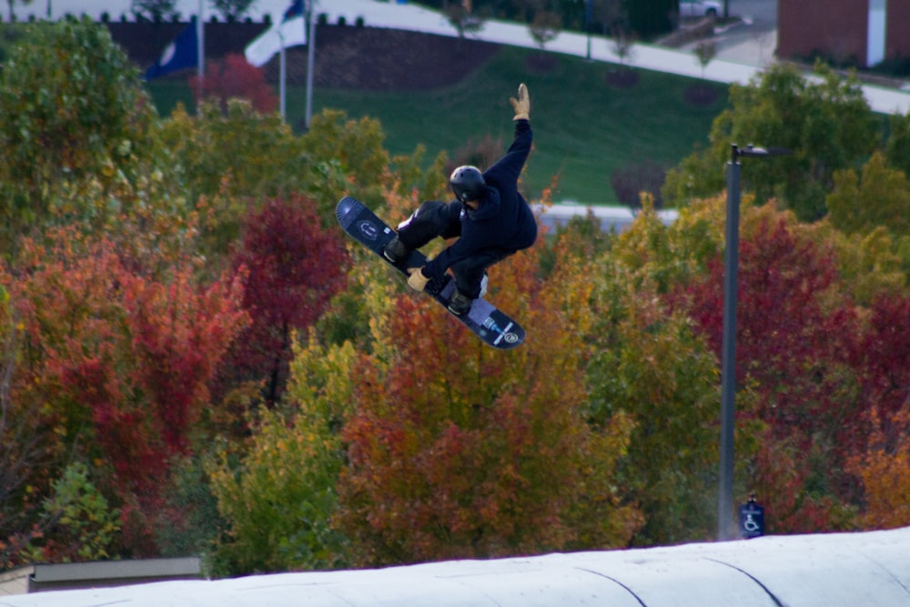 Un hombre volando por el aire mientras monta una tabla de snowboard