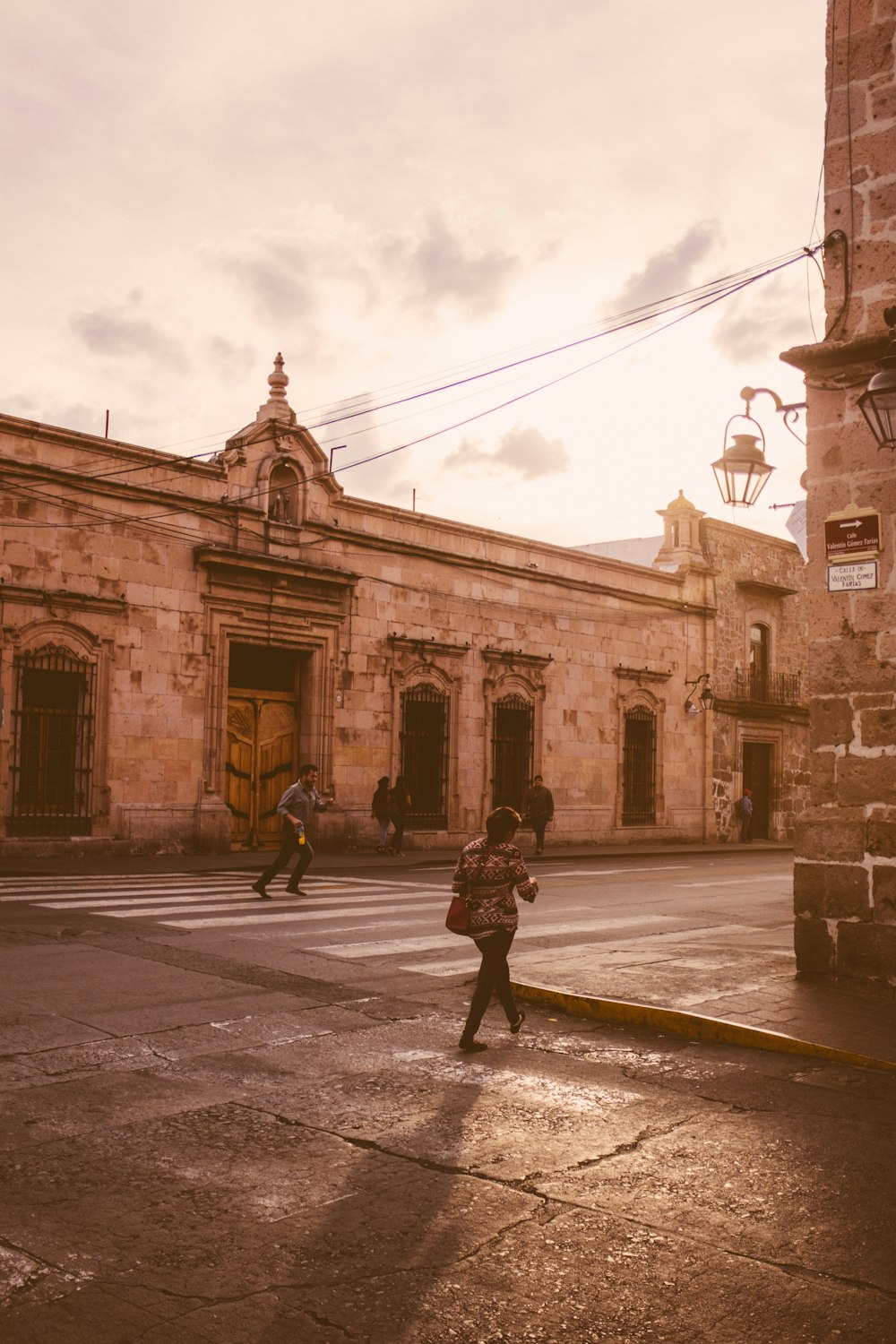 a person walking down a street in front of a building