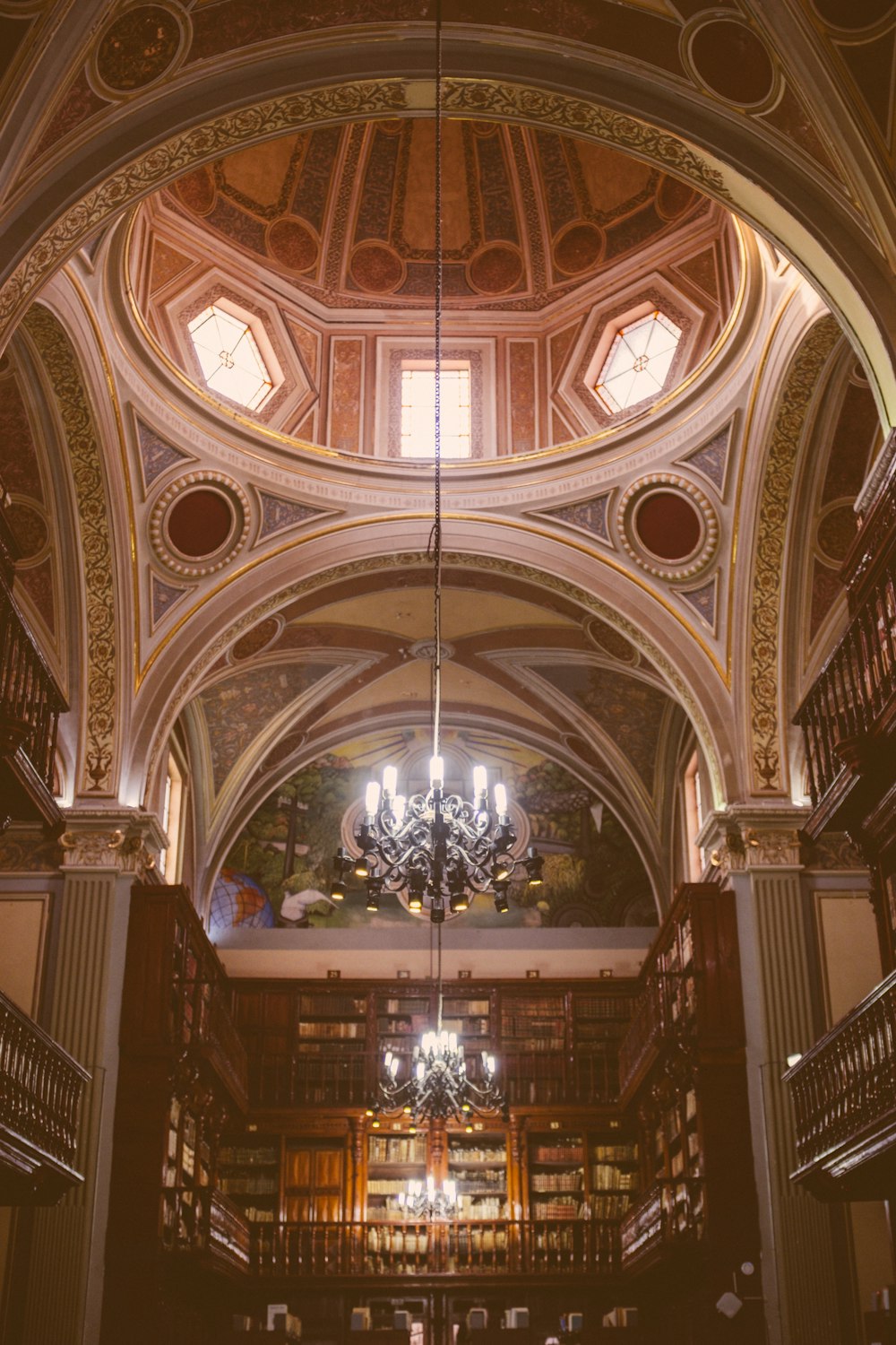 a library with a chandelier and a chandelier hanging from the ceiling
