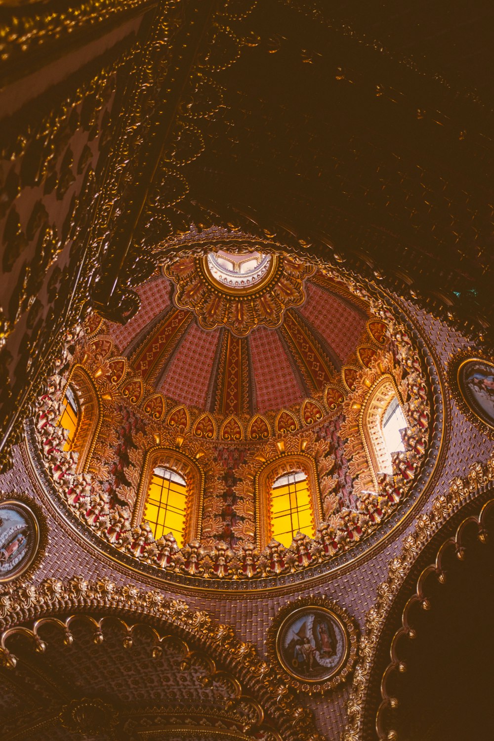 the ceiling of a building with a dome and stained glass windows