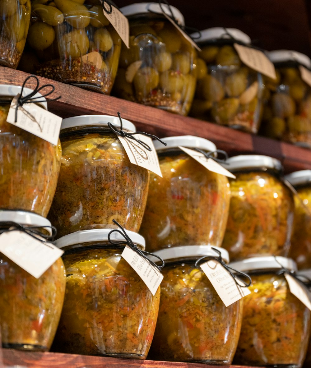 a shelf filled with jars of pickles and olives