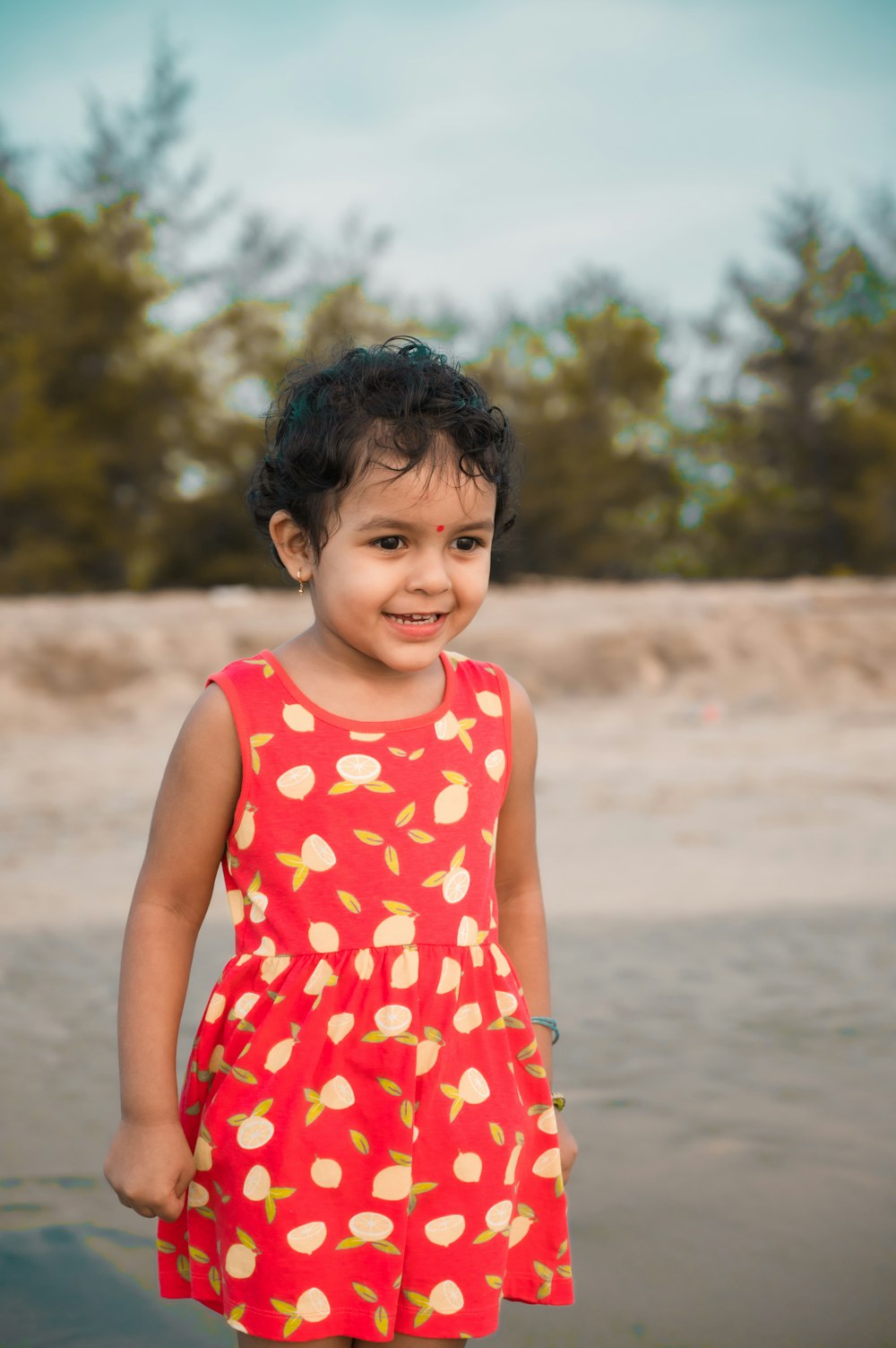 a little girl that is standing in the sand